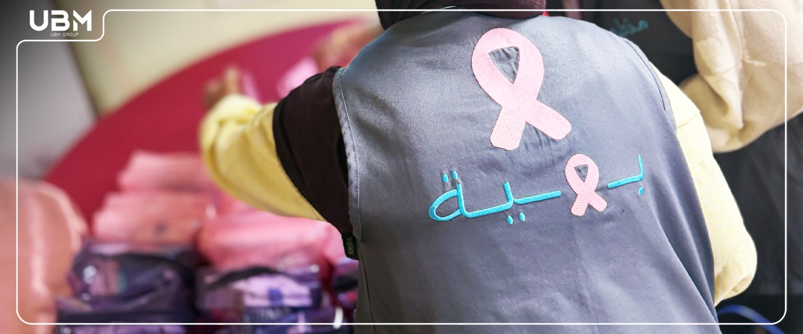 Baheya volunteer with pink ribbon emblem